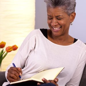 Mature black woman writing in journal